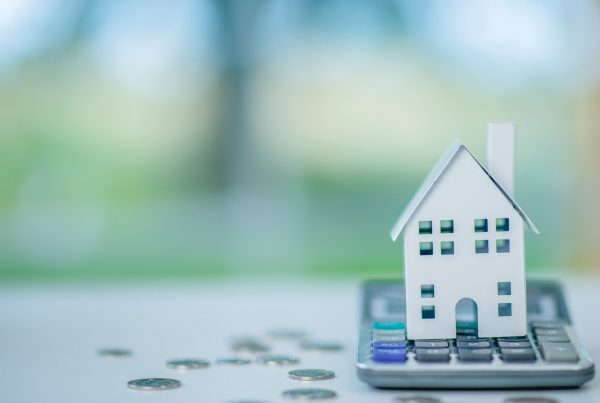 Paper house sitting on top of calculator