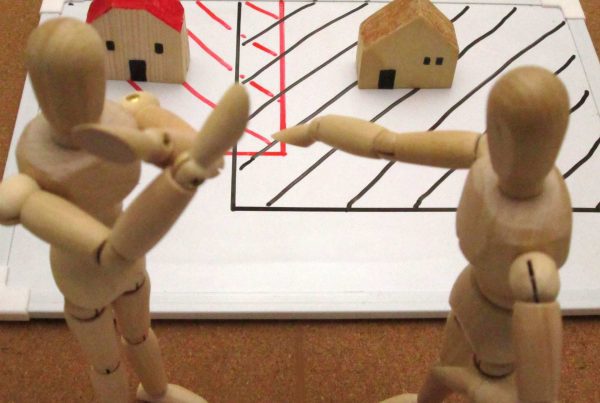 Wooden people fighting over property