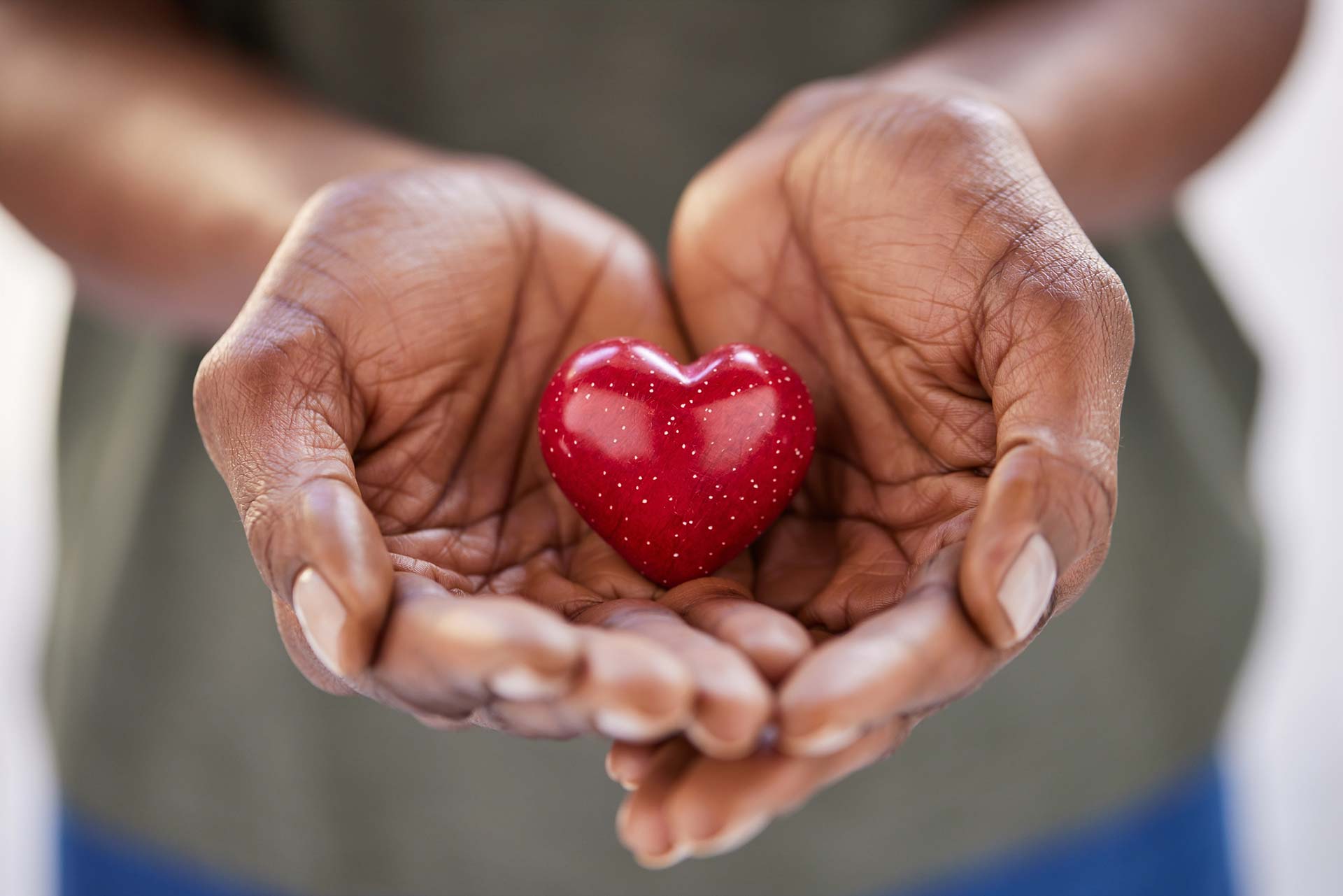 Hands holding red wooden heart
