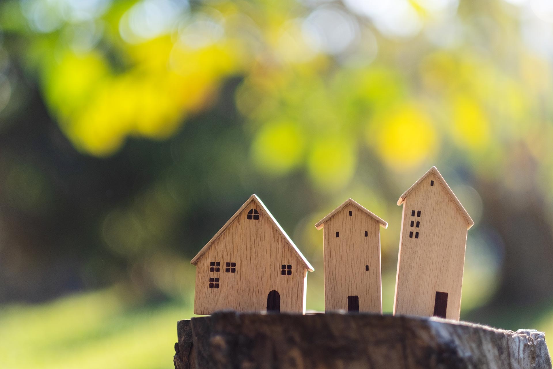 miniature wooden houses on tree stump